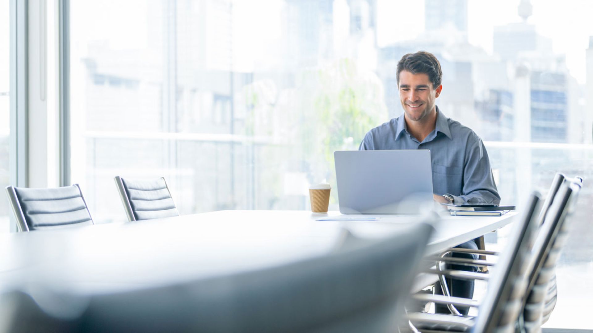 man on laptop sitting at conference table